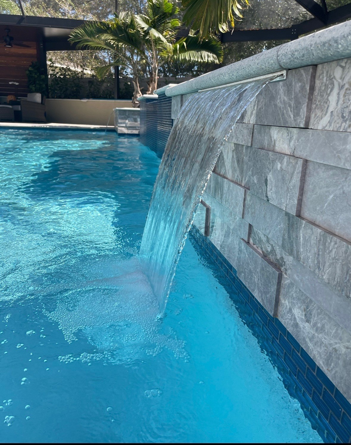 Clear residential pool with a premium waterfall feature in Tampa